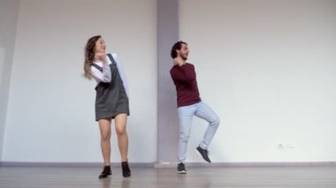 Bir çift dansçı kameranın önünde farklı dans stillerini karıştırıyor.