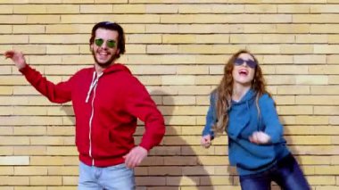 Güneş gözlüğü takan çift senkronize bir şekilde dans ediyor.