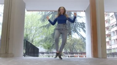 Genç, gülümseyen bir kadın ustaca tekrar ziyaret edilen bir hi-hat performansı sergiliyor.