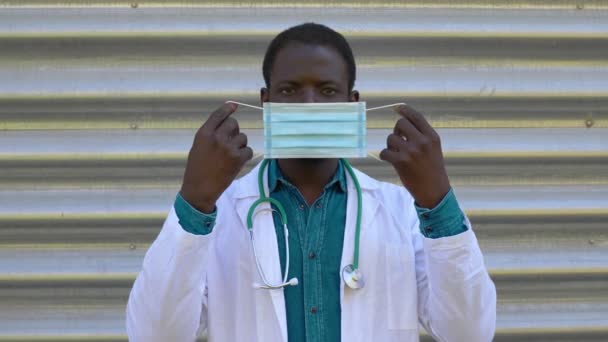 Covid19 Στοχαστικός Μαύρος Γιατρός Φορώντας Μάσκα Κοιτάζοντας Την Κάμερα — Αρχείο Βίντεο