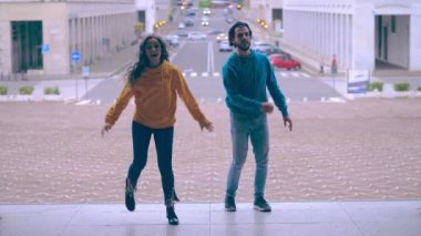 Genç çift merdivenlerde dans ederek modern bir hi-hat yapıyor.