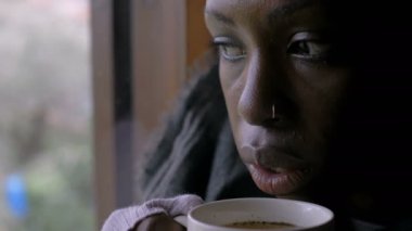 Hastalık, grip - Ateşli genç siyah kadın sıcak çay içiyor