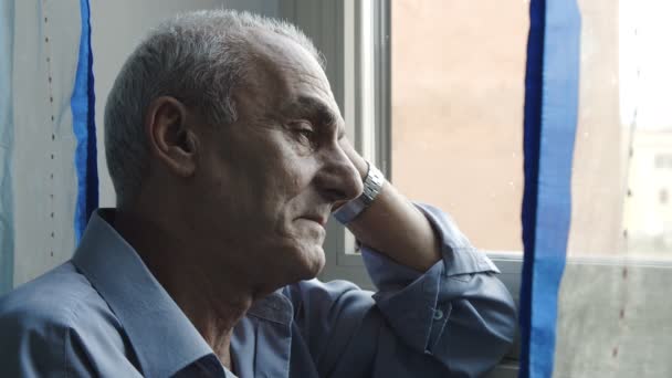 Szomorú és magányos férfi bajok depressziós ül az ablak mellett — Stock videók