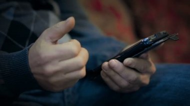 Kırmızı koltukta cep telefonuyla yaşlılar. Sadece el