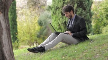 işadamı bir dokunmatik ekran cihaz tutan bir parkta