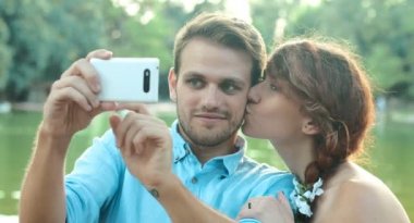 bir kamu bahçe içinde küçük bir göl yakınındaki selfie yapma aşık genç Çift
