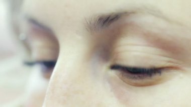 Mavi gözlü genç bir kızın yakın çekimi (piercing ile) gözleri açar ve kapatır)