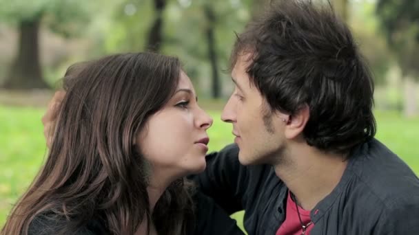 Vackert ungt par kyssar i parken — Stockvideo