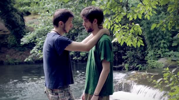 Com amor. Beija. dois jovem gay homem com um lago no o fundo — Vídeo de Stock