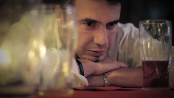Отчаянный человек за столом в пабе со стаканом холодного пива — стоковое видео