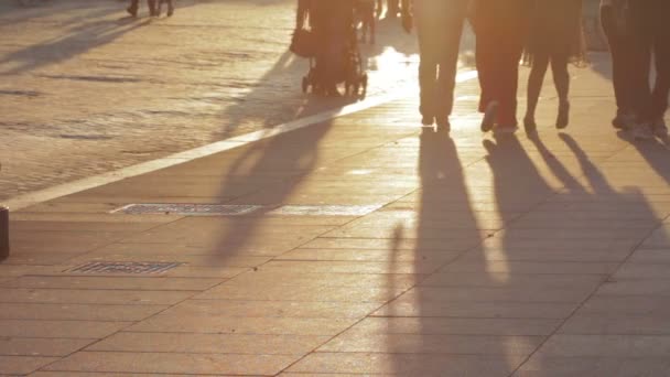 Mensen lopen bij zonsondergang op de stoep in een stad, lange schaduwen van mensen-Rome, Italië, 10 juni, 2015 — Stockvideo