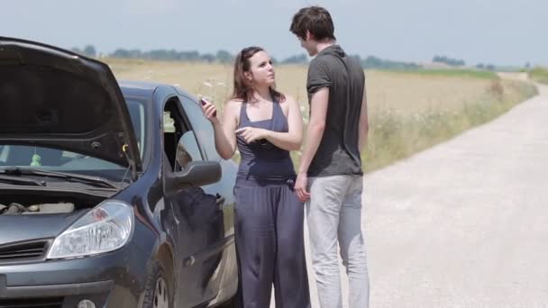 Man helps a woman with her broken down car — Stock Video