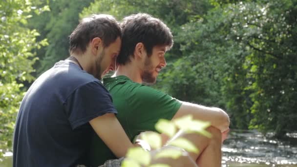 Два молодых гея обнимают друг друга — стоковое видео