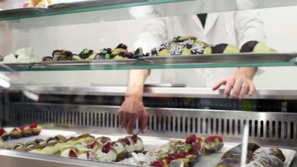 Boulanger vend des pâtisseries à un client — Video