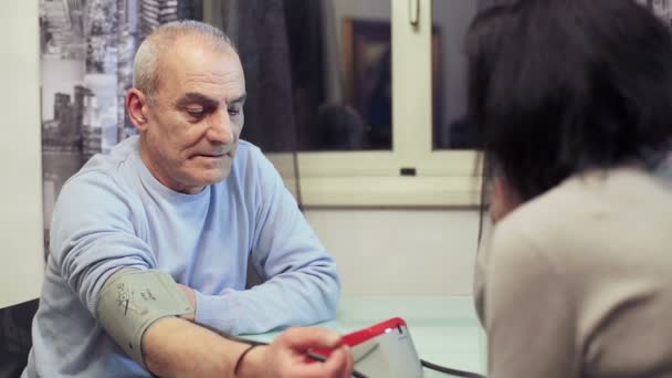 Mujer medir la presión arterial a un anciano — Vídeos de Stock