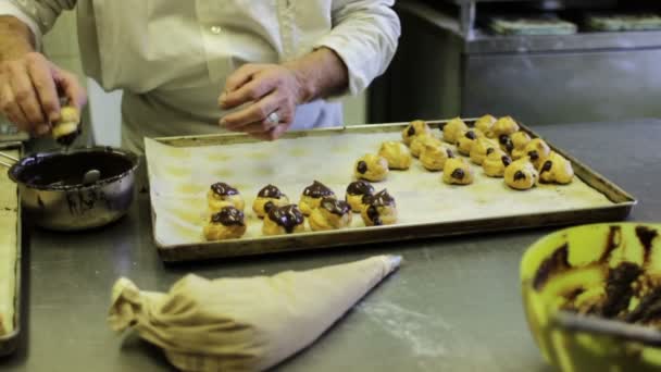 Кондитер готовит шоколадный эклер — стоковое видео