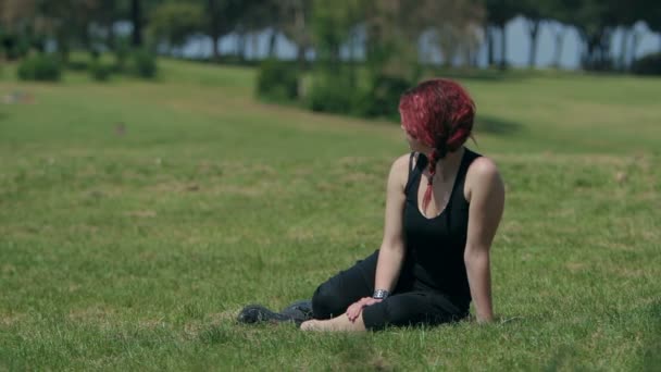 Belle rousse femme au repos après avoir fait du jogging dans le parc — Video