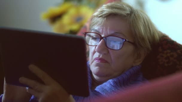 Frau nutzt Facebook auf Tablet: Spiegelung auf der Brille — Stockvideo