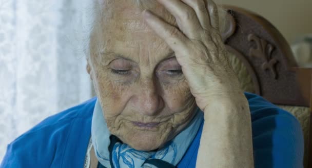 Portret van disperate en depressief oude vrouw, hand op het hoofd, openen en sluiten van de ogen — Stockvideo