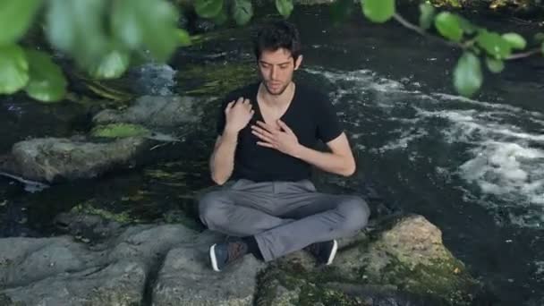 Hombre rezando cerca del río — Vídeo de stock
