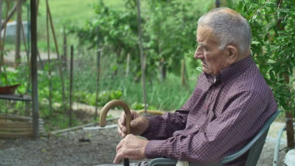 Gubbe som är avkopplande på en stol — Stockvideo