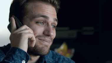 genç ve yakışıklı bir adam gülümseyerek telefonu, arama sırasında değişiklik ruh hali vardır: 4k