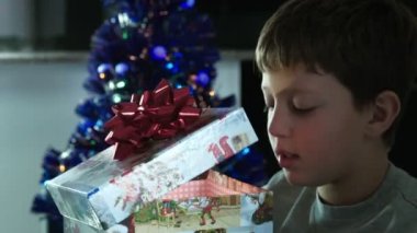 mutlu çocuk bir Noel hediyesi güzel bir kutu ışık ile açılış yayan