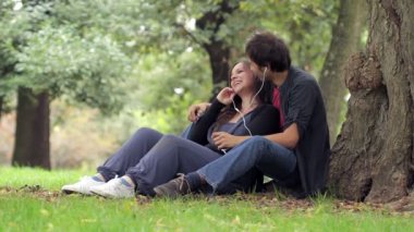 Genç çiftin birlikte piknik kulaklıktan müzik dinlemeyi seven