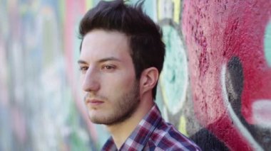 renkli bir duvara yaslanmış ağlayan bir adam portresi