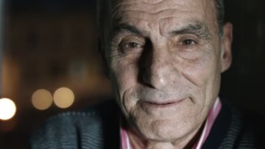 yaşlı adam kameraya gülümseyen: gece şehir ışıkları arka planda ile vurdu
