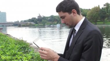 genç işadamı parkta tablet ile çalışma