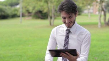 genç işadamı parkta tablet ile çalışma