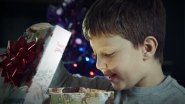 mutlu çocuk bir Noel hediyesi güzel bir kutu ışık ile açılış yayan