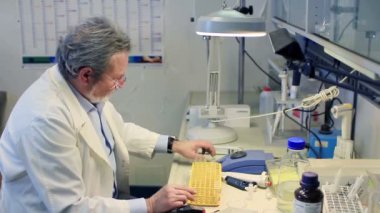 Otomatik pipet ve girdap ile laboratuvarda çalışan bir scentist.