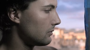 üzgün genç adam pencereden dışarı bakarak
