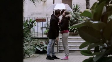 bir adam güzel bir kadın ve Yağmurda öpüşme ile flört ediyor