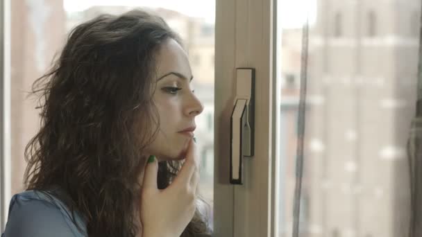 Mujer mirando por la ventana — Vídeo de stock