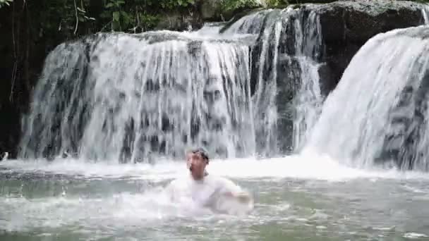 Un joven sale del agua y celebra sus éxitos - regocijarse — Vídeos de Stock