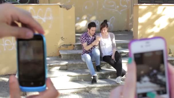Två killar klantar sig gör rolig utgör - mobiltelefoner - foto - gör ansikten — Stockvideo