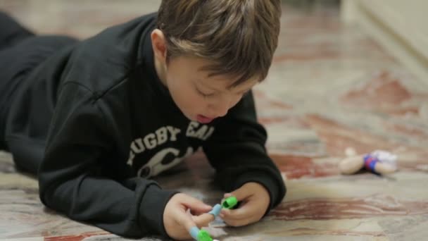 Child having fun with a doll on the floor — Stock Video