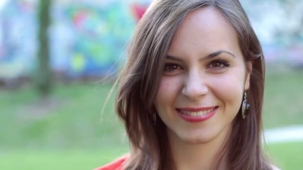 Primer plano de una joven y hermosa mujer sonriendo en el parque - retrato — Vídeos de Stock