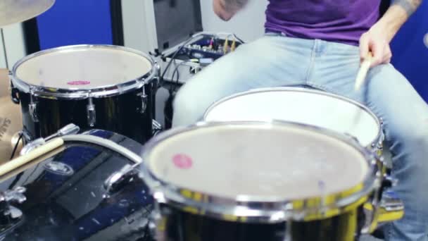 Татуированный молодой человек играет на барабанах — стоковое видео