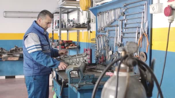 Mecánico de automóviles reparando una parte de un motor de coche — Vídeos de Stock