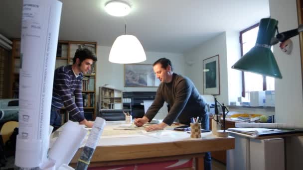 Architecte, dolly Deux architectes examinant un plan dans un bureau — Video