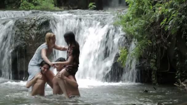 Мальчики и девочки веселятся в реке, борются и плещутся в воде — стоковое видео