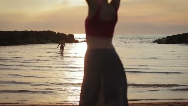 Mulher vestida no amor corre para o seu homem no mar - abraços e beijos - pôr do sol — Vídeo de Stock