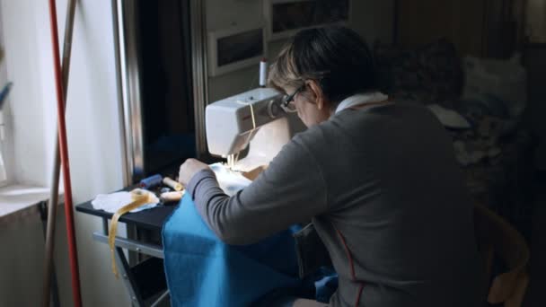 Trabajo manual en la máquina de coser en casa hecho por una mujer mayor — Vídeo de stock