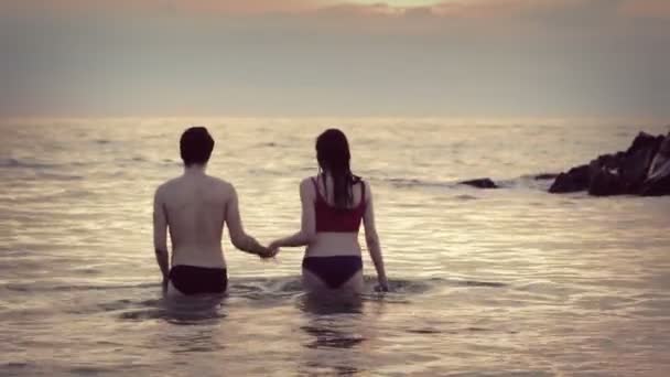 Хлопчик і дівчинка цілуються в морі — стокове відео