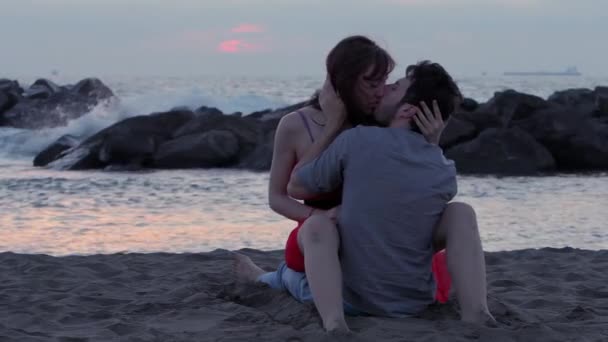 An attractive couple kissing on the beach — Stockvideo