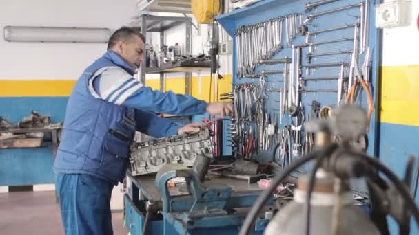 Auto mechanic repairing a part of a car engine — Stock Video